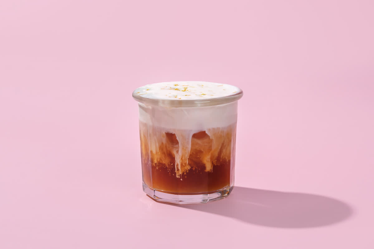An iced coffee under a cap of citrus cold foam