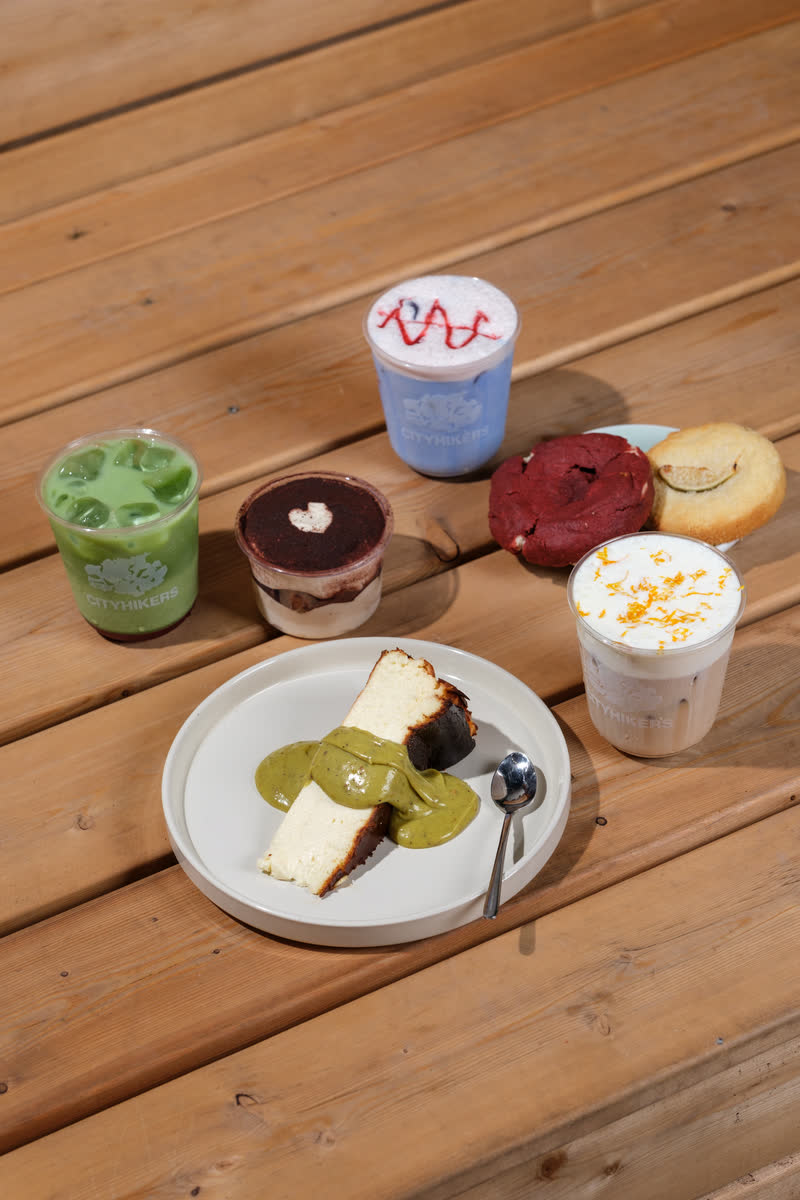 Cheesecake, cookies and drinks spread across a wood table